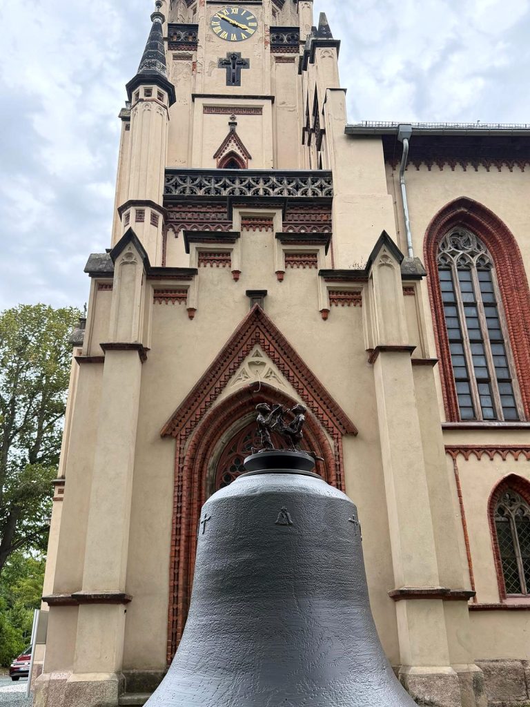 Friedensglocke mit Figurengruppe vor dem Portal der Matthäuskirche
